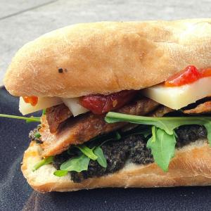 Secreto sandwich with black olive tapenade and Manchego