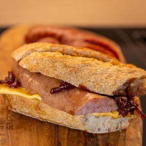 Smoked sausage bun with cheddar and caramelized onions